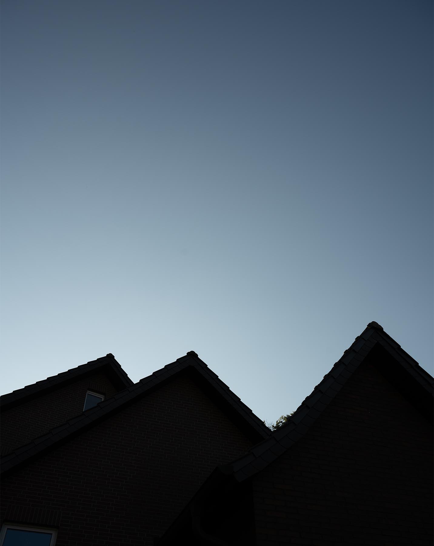 Hausdächer im Profil vor blauem Abendhimmel