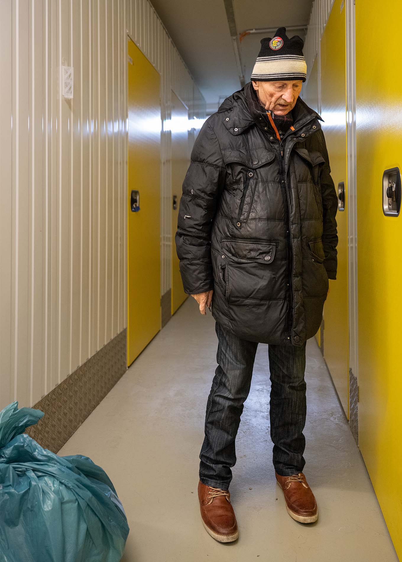 Die Katze steht mit gesenktem Kopf vor seinem geschlossen Lagerraum.