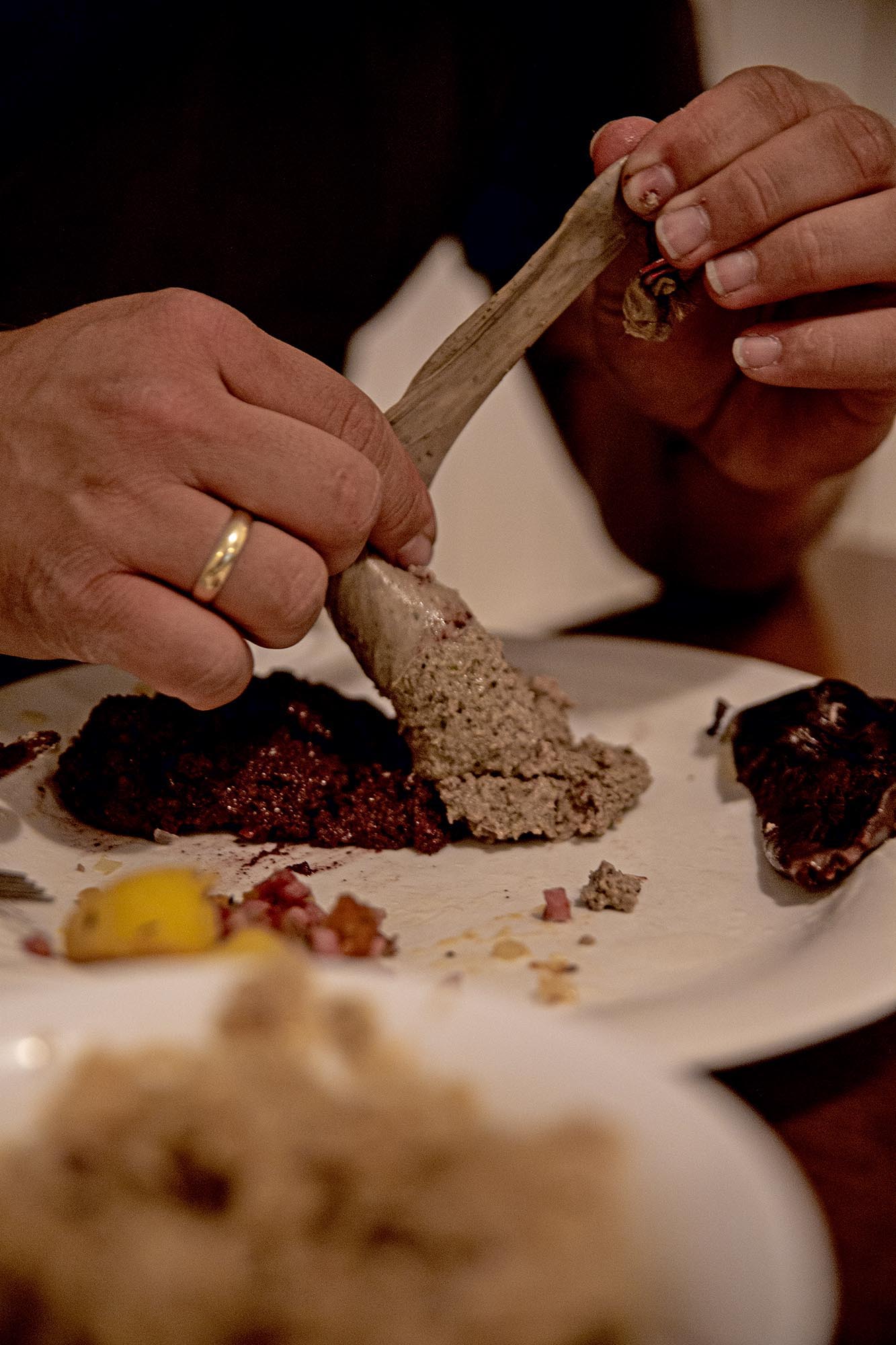 Eine gekochte Leberwurst wird neben einem Haufen Blutwurst ausgedrückt.