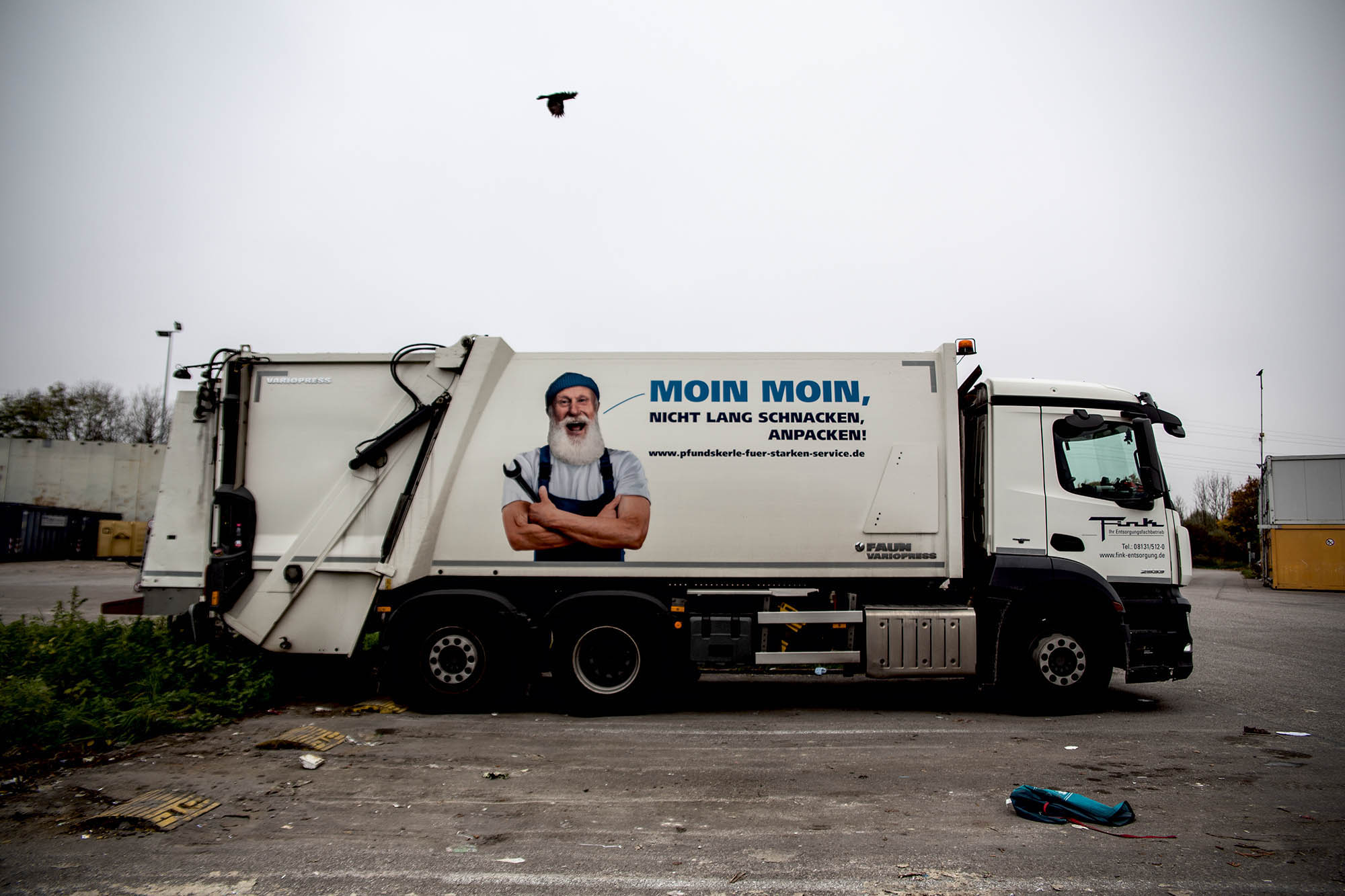 Ein LKW der Müllabfuhr mit einem Bild eines bärtigen Mannes (Mega Bart, bin voll neidisch) und der Aufschrift: Moin Moin, nicht lang schnacken, anpacken!